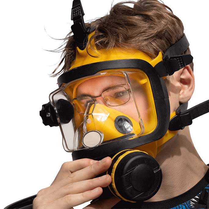 Person wearing a yellow respirator mask with a clear visor on a white background