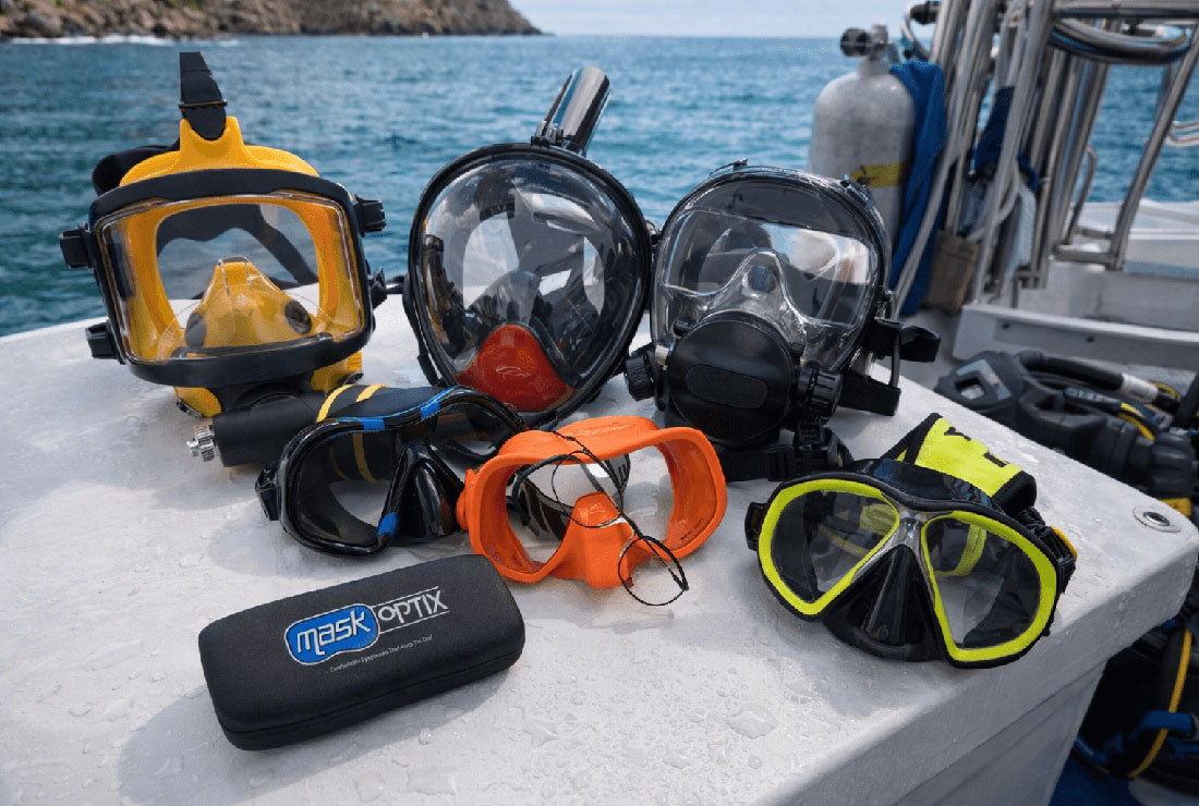 Collection of diving masks and snorkels on a boat with water in the background